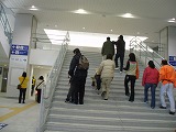 駅の正面階段を上る視覚障害者と付き添いの人達